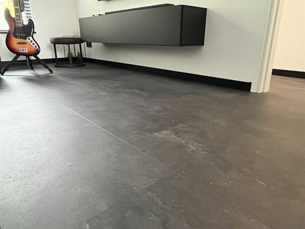 PVC-vloer in donkere betonlook onder een zwevend tv-meubel