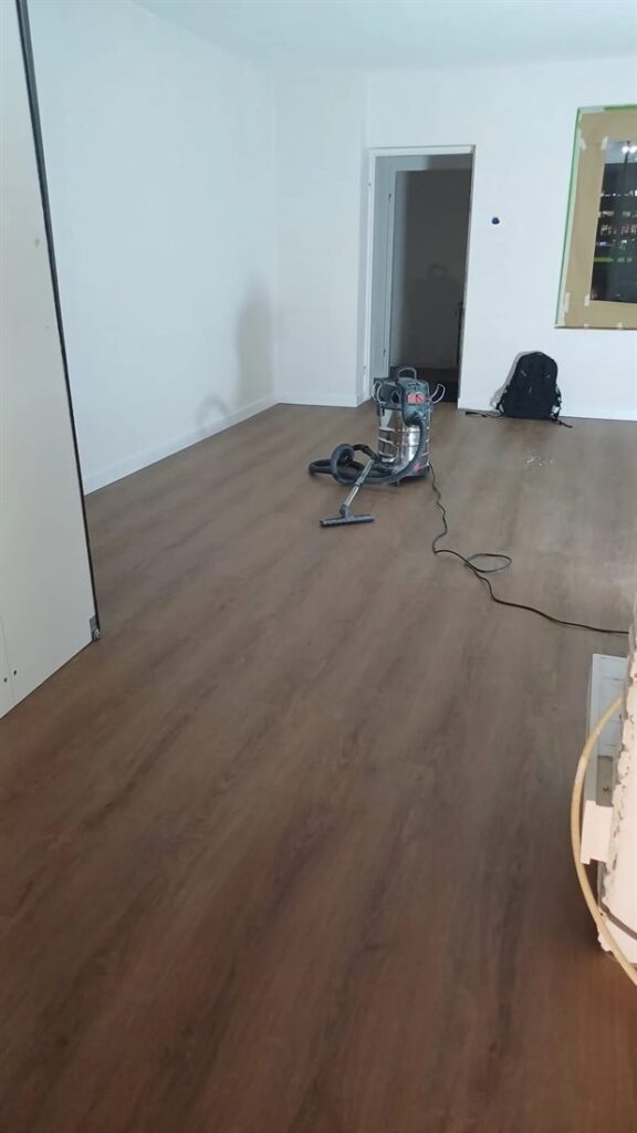Net gelegde PVC-vloer met planken in donkere houtlook