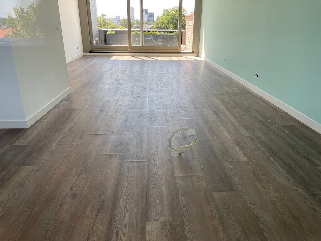 PVC-vloer met houtlook planken in een lichte kamer met balkondeuren