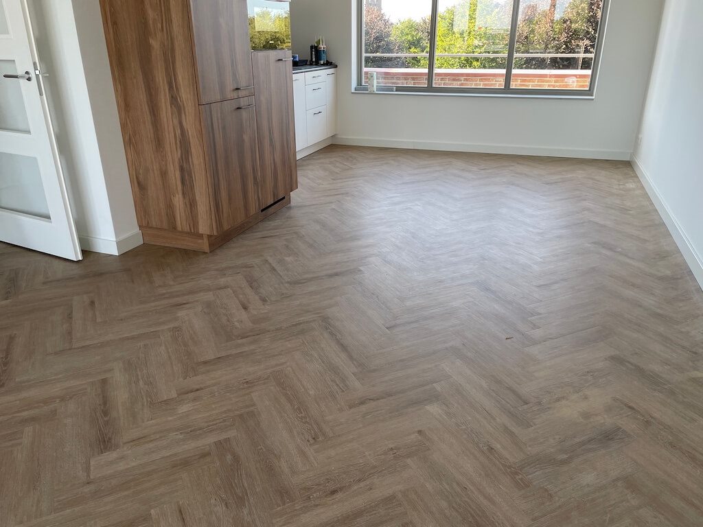 Visgraat PVC-vloer in een open keuken met houten kastenwand