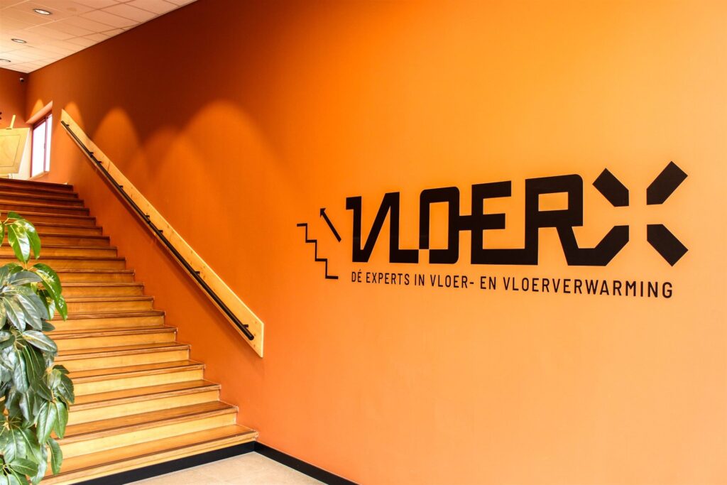Entree van de VloerX-showroom in Leerdam met logo en trap