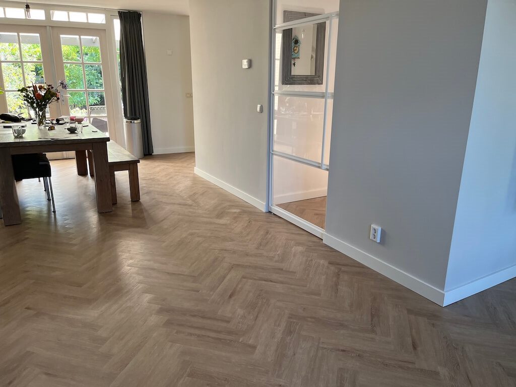 Visgraat PVC-vloer in een eetkamer met glazen deur