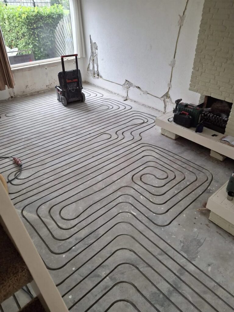 Vloerverwarming ingefreesd in de woonkamer tijdens een verbouwing